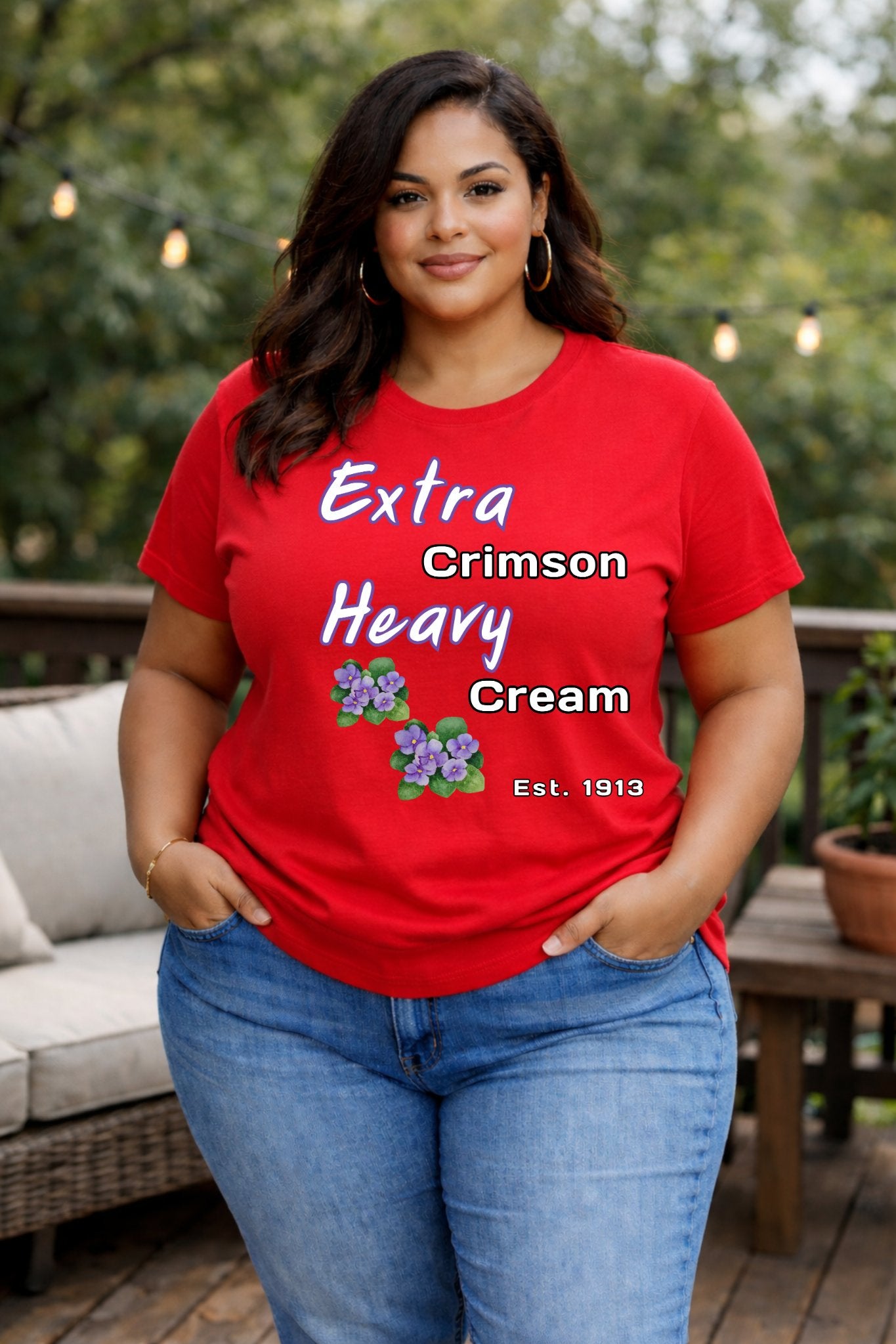 Woman wearing a red t-shirt with text and graphics, standing outdoors.